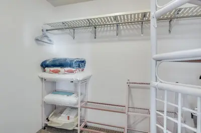 a closet with white walls and white shelves at Sand-Crest Overlook - Moondrifter 201 in Panama City Beach