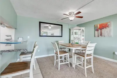 a dining room with a table and chairs at Sand-Crest Overlook - Moondrifter 201 in Panama City Beach