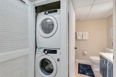 a laundry room with a washer and dryer in it at Sand-Crest Overlook - Moondrifter 201 in Panama City Beach
