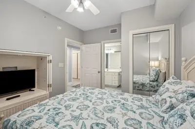 a bedroom with a bed and a flat screen tv at Majestic Condo- Tower 2 #206 3 BR 3 BA Low floor! in Panama City Beach