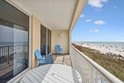 a balcony with a table and chairs and the beach at Majestic Condo- Tower 2 #206 3 BR 3 BA Low floor! in Panama City Beach