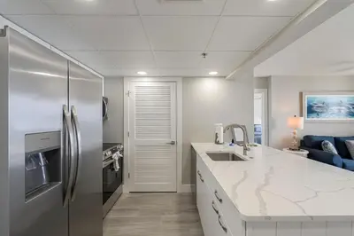 a kitchen with a stainless steel refrigerator and a counter at Long Beach Tower 3 #305 Beachfront Renovation in Panama City Beach