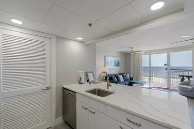 a kitchen with a sink and a view of the ocean at Long Beach Tower 3 #305 Beachfront Renovation in Panama City Beach