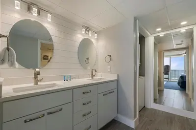 a bathroom with two sinks and a large mirror at Long Beach Tower 3 #305 Beachfront Renovation in Panama City Beach