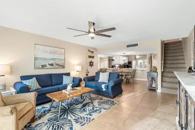 a living room with a blue couch and a table at Largo Mar 143 - Sand-Side Paradise Townhome in Panama City Beach