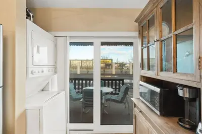 a kitchen with a view of a table and a balcony at Largo Mar 143 - Sand-Side Paradise Townhome in Panama City Beach