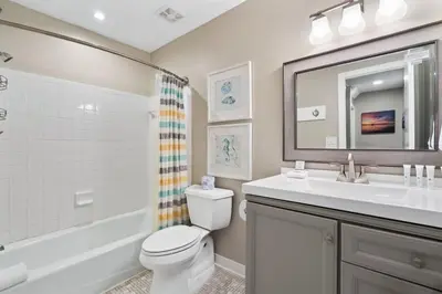 a bathroom with a toilet and a sink and a mirror at Largo Mar 143 - Sand-Side Paradise Townhome in Panama City Beach