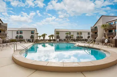 a pool at a resort with chairs and condos at Largo Mar 143 - Sand-Side Paradise Townhome in Panama City Beach