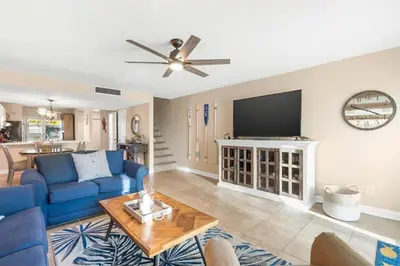 a living room with a blue couch and a tv at Largo Mar 143 - Sand-Side Paradise Townhome in Panama City Beach