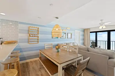 a living room with a table and a couch at Commodore 606 3 BR 3 BA Sleeps 12 in Panama City Beach