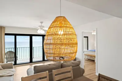 a living room with a couch and a chandelier at Commodore 606 3 BR 3 BA Sleeps 12 in Panama City Beach