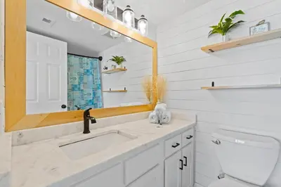 a bathroom with a sink and a mirror at Commodore 606 3 BR 3 BA Sleeps 12 in Panama City Beach