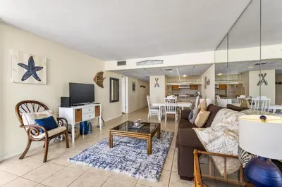 a living room with a couch and a table at Edgewater Windward 104 - 1 BR beachfront sleeps 4 in Panama City Beach