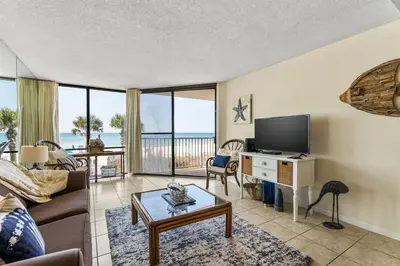 a living room with a couch and a tv at Edgewater Windward 104 - 1 BR beachfront sleeps 4 in Panama City Beach