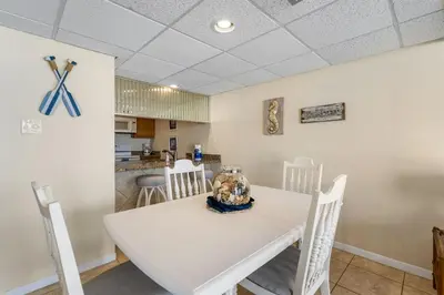 a dining room with a white table and chairs at Edgewater Windward 104 - 1 BR beachfront sleeps 4 in Panama City Beach