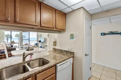 a kitchen with a sink and a view of the ocean at Edgewater Windward 104 - 1 BR beachfront sleeps 4 in Panama City Beach