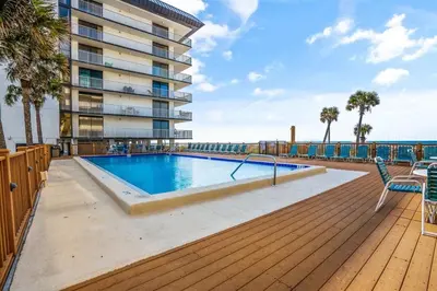 a swimming pool on a deck next to a building at Edgewater Windward 104 - 1 BR beachfront sleeps 4 in Panama City Beach