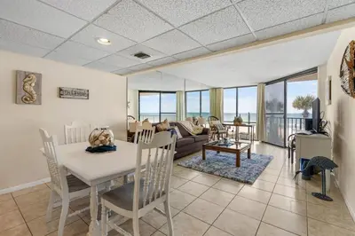 a living room with a table and a couch at Edgewater Windward 104 - 1 BR beachfront sleeps 4 in Panama City Beach