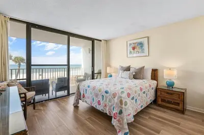 a bedroom with a bed and a view of the ocean at Edgewater Windward 104 - 1 BR beachfront sleeps 4 in Panama City Beach