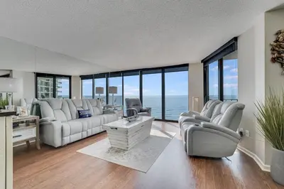 a living room with white furniture and a view of the ocean at Edgewater T3 #802 - 2 BR 2 BA Amazing views in Panama City Beach