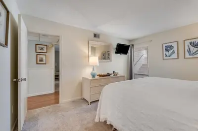 a bedroom with a white bed and a television at Edgewater T3 #802 - 2 BR 2 BA Amazing views in Panama City Beach