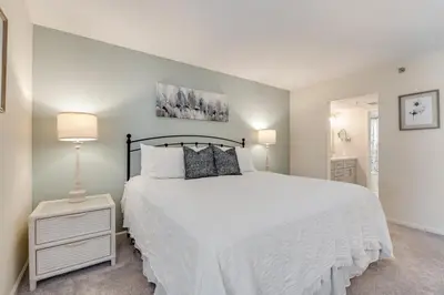 a bedroom with a large white bed and a lamp at Edgewater T3 #802 - 2 BR 2 BA Amazing views in Panama City Beach