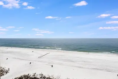 a beach with people on the sand and the ocean at Edgewater T3 #802 - 2 BR 2 BA Amazing views in Panama City Beach