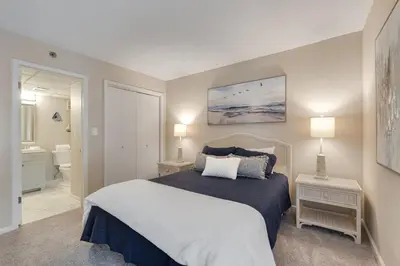 a bedroom with a large bed and a bathroom at Edgewater T3 #802 - 2 BR 2 BA Amazing views in Panama City Beach