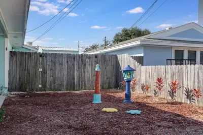a toy fire hydrant in front of a fence at 7131 Sunset Ave - Cottage by The Sea with pool in Panama City Beach