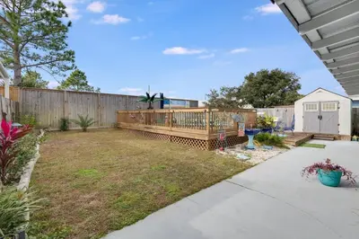 a backyard with a wooden fence and a yard at 7131 Sunset Ave - Cottage by The Sea with pool in Panama City Beach