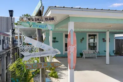 a street sign in front of a house at 7131 Sunset Ave - Cottage by The Sea with pool in Panama City Beach