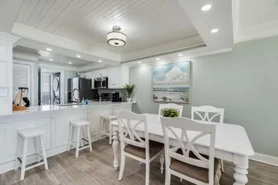 a kitchen with a white table and white chairs at Edgewater T1 #709 - Sleeps 6 Amazing gulf views! in Panama City Beach