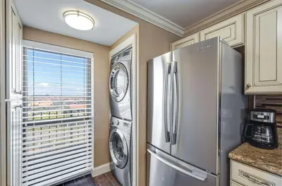 a kitchen with a refrigerator and a washer and dryer at Edgewater Tower 1 #609 - Lagoon Tower - 2 BR 2 BA in Panama City Beach
