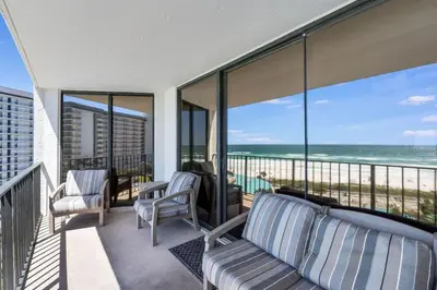 a balcony with a couch and chairs on a balcony overlooking the ocean at Edgewater Tower 1 #609 - Lagoon Tower - 2 BR 2 BA in Panama City Beach