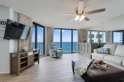 a living room with a couch and a flat screen tv at Edgewater T2 #911 Sleeps 10 with amazing sunsets! in Panama City Beach