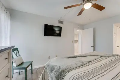 a white bedroom with a ceiling fan and a bed at Edgewater T2 #911 Sleeps 10 with amazing sunsets! in Panama City Beach