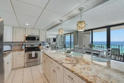 a large kitchen with a view of the ocean at Edgewater T2 #911 Sleeps 10 with amazing sunsets! in Panama City Beach