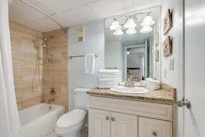 a bathroom with a sink and a toilet and a bath tub at Edgewater T2 #911 Sleeps 10 with amazing sunsets! in Panama City Beach