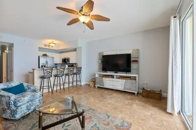 a living room with a couch and a tv at Celadon 307 1 BR 2 BA Oceanfront condo in Panama City Beach