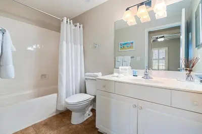a bathroom with a toilet and a sink and a mirror at Celadon 307 1 BR 2 BA Oceanfront condo in Panama City Beach