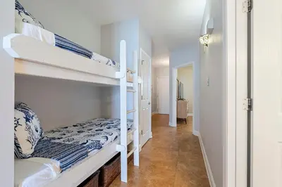 a room with two bunk beds and a hallway at Celadon 307 1 BR 2 BA Oceanfront condo in Panama City Beach