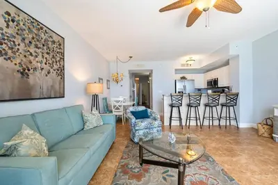 a living room with a blue couch and a table at Celadon 307 1 BR 2 BA Oceanfront condo in Panama City Beach