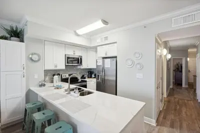 a kitchen with white cabinets and a white counter top at Celadon 1506 Beachfront 1 BR 2 BA sleeps 6 in Panama City Beach
