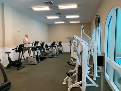 a man in a gym with several tread machines at Celadon 1506 Beachfront 1 BR 2 BA sleeps 6 in Panama City Beach