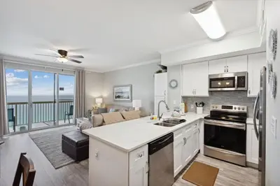 a kitchen and living room with a view of the ocean at Celadon 1506 Beachfront 1 BR 2 BA sleeps 6 in Panama City Beach