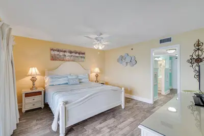 a bedroom with a bed and a ceiling fan at Commodore 605 3 BR 3 BA with 2 Beachfront Masters in Panama City Beach