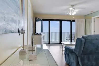 a living room with a blue couch and a glass table at Commodore 605 3 BR 3 BA with 2 Beachfront Masters in Panama City Beach