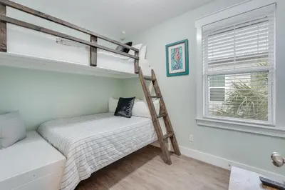 a bedroom with a bunk bed and a window at Coastal Sands - 219 Sands Street in Panama City Beach
