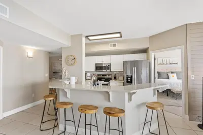 a kitchen with a counter and stools in a room at Celadon 109 - 3BR 3BA in Panama City Beach
