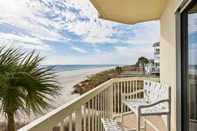 a balcony with two white chairs and the beach at Celadon 109 - 3BR 3BA in Panama City Beach